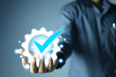 man holding digital asset of gear with blue checkmark in it